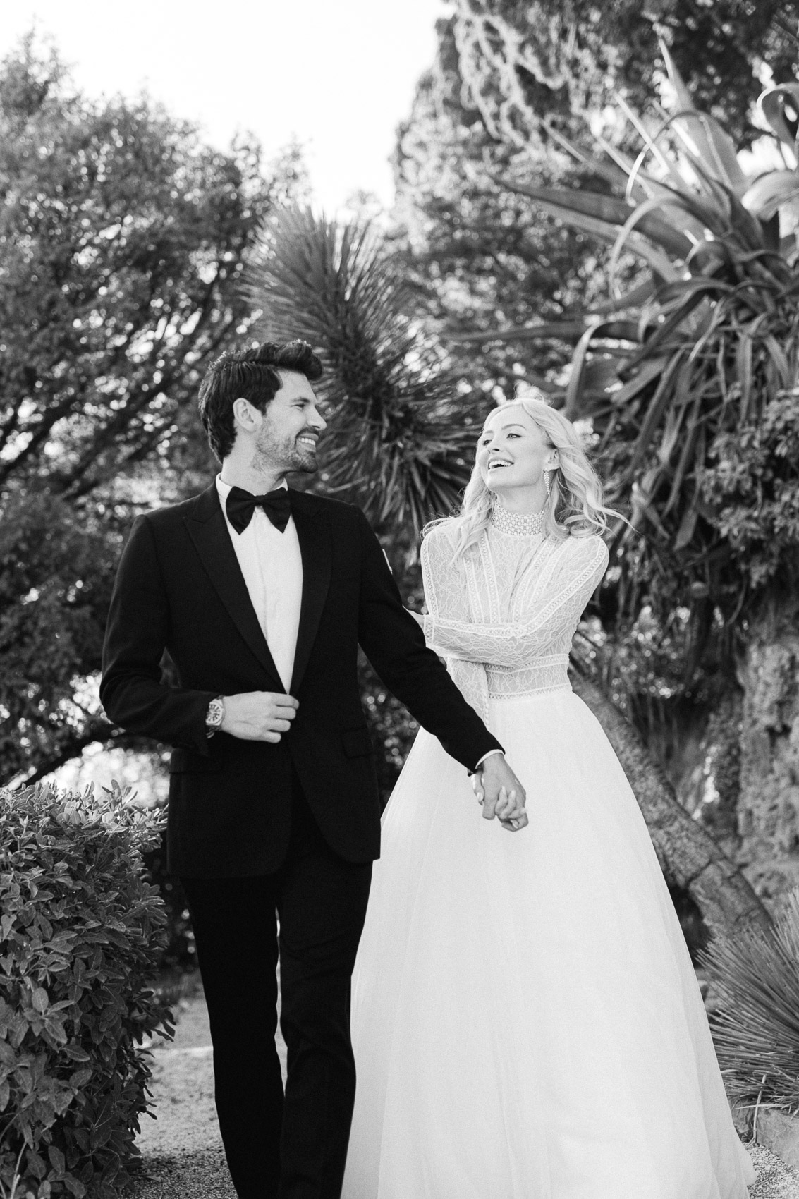 married couple walking and looking at each other hand in hand at the residence of cap brun