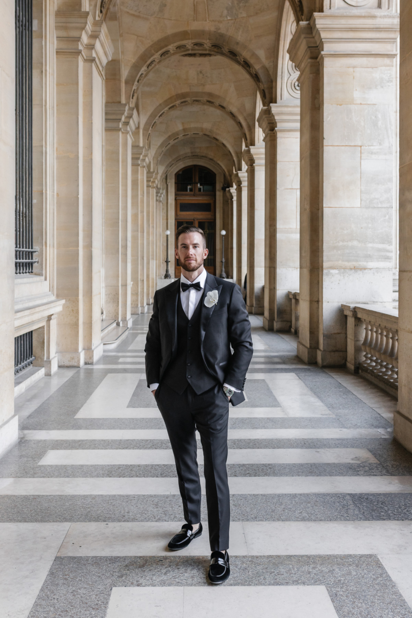 Elegant groom portrait in Paris under classic French architecture, editorial style by Olivier Neuville Photography.