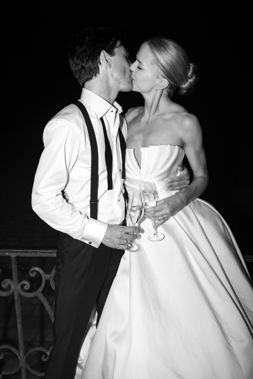 ride and groom sharing a romantic champagne kiss during their elegant Paris wedding, captured by Olivier Neuville Photography.