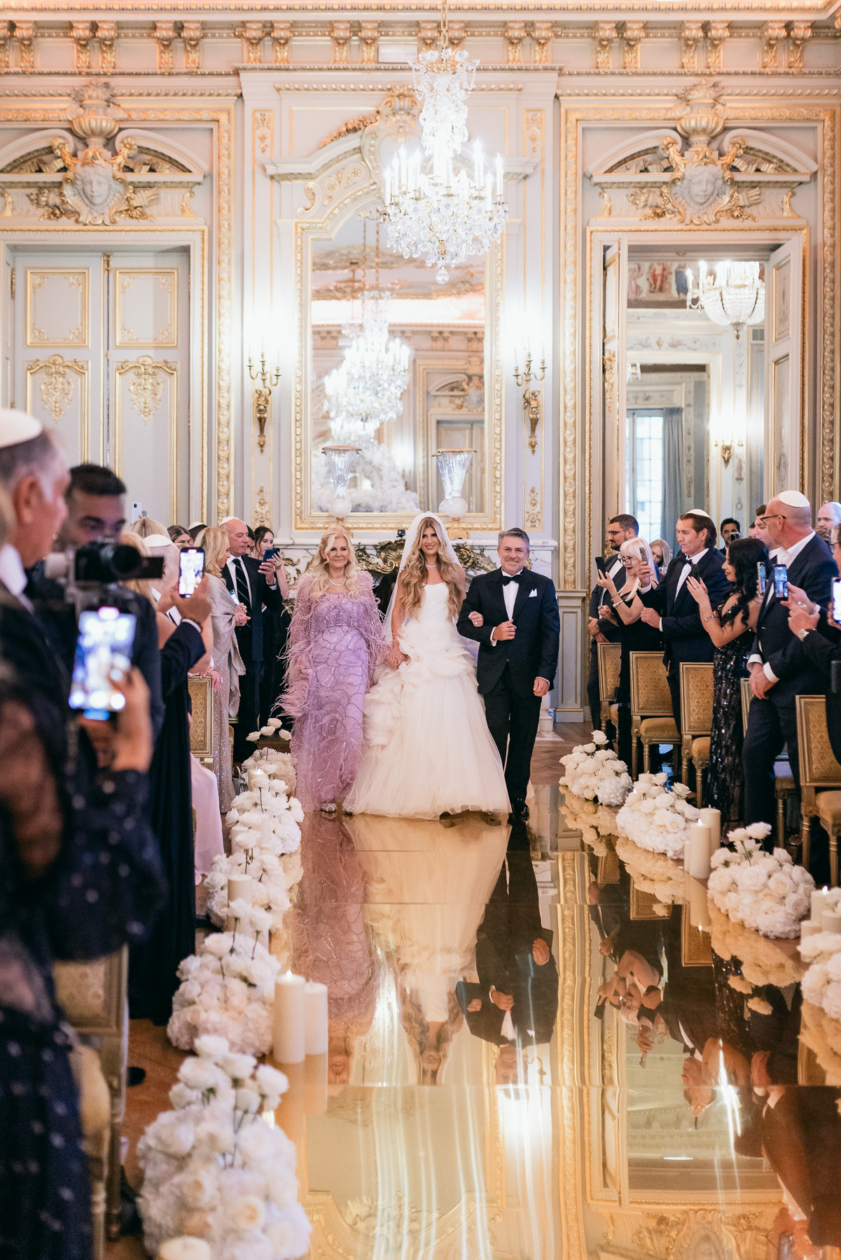 Luxury indoor wedding ceremony at a Paris palace with floral decor, captured by Olivier Neuville.